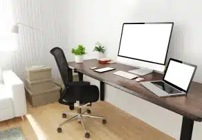 A bright WFH desk setup featuring a computer, laptop, and a black mesh ergonomic office chair Malaysia professionals prefer for comfortable home workspaces.