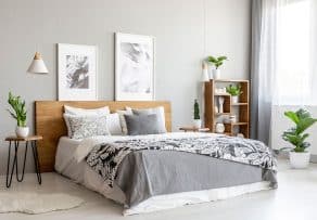 A modern light-wood platform bed and minimalist bedroom furniture in a contemporary room.