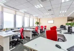 A modern open-plan workspace featuring coordinated desks and red ergonomic chairs from a professional office furniture supplier Malaysia.