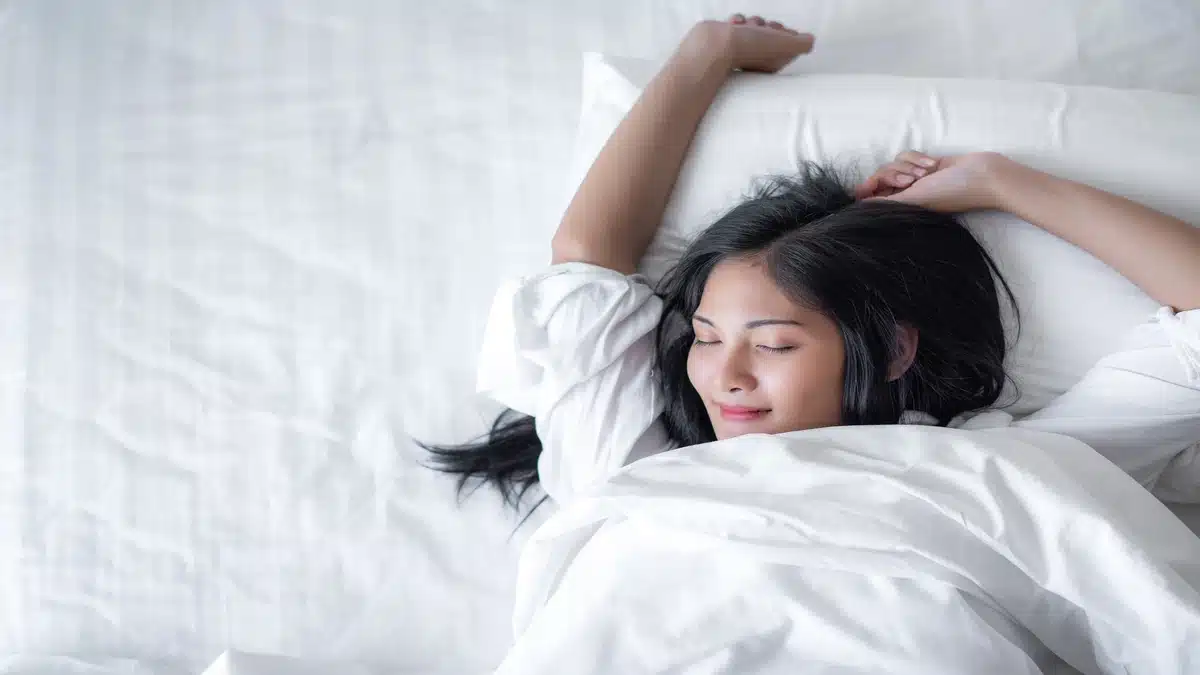 Woman sleeping peacefully on a comfortable queen size mattress in Malaysia.