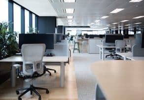 An open-plan startup workspace featuring light-gray mesh chairs that offer great comfort and value for an affordable office chair price.