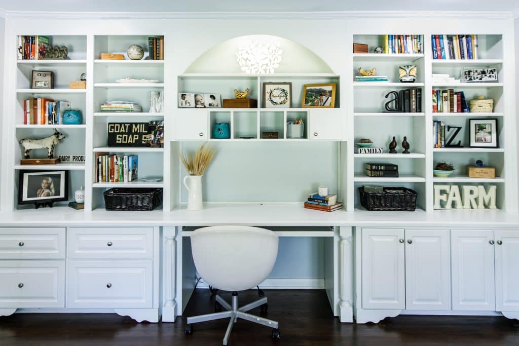 Indoor home office with desk and built in wood shelving